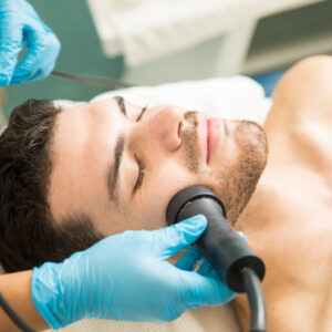 Closeup of a handsome young man getting facial rejuvenation therapy in a health spa